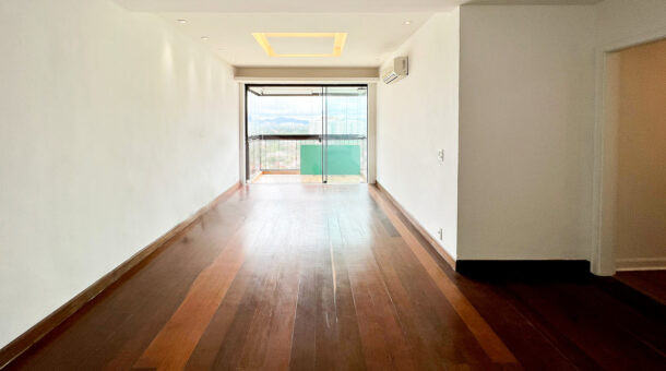 Imagem da sala com piso de madeira do apartamento reformado à venda no Novo Leblon