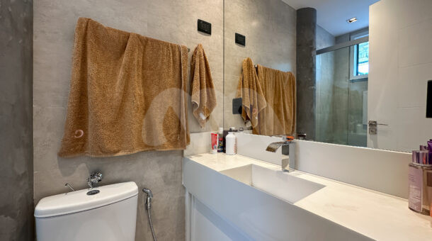 Imagem de banheiro com bancada de porcelanato da casa triplex à venda no condomínio Art Life, no Recreio dos Bandeirantes.
