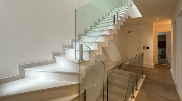 Imagem de corredor com escada da casa triplex à venda no condomínio Art Life, no Recreio dos Bandeirantes.