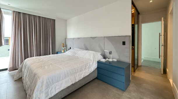 Imagem de suite com cabeceira planejada e cama de casal da casa triplex à venda no condomínio Art Life, no Recreio dos Bandeirantes.